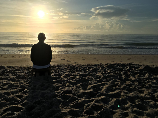 Foto of Annelie, in the morning stillness, sitting on a meditation bench, being; resting my mind.
